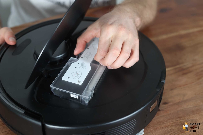Der Roborock Q Revo steht mit offener Klappe auf dem Boden.